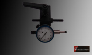 A dial indicator gauge on a dark background, used for precise measurements.
