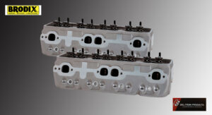 Two metallic engine cylinder heads with visible ports and valves.
