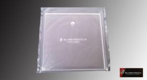A sealed transparent sleeve containing a white square item with text.