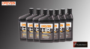 Row of DRIVEN HR motor oil bottles with black caps on gray background.