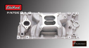 Silver car engine intake manifold with multiple ports on a dark surface.