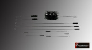 Various gun cleaning brushes and rods laid out on a flat surface.