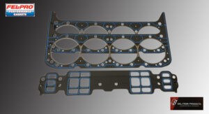 Two metal engine gaskets with multiple holes and cutouts on a table.