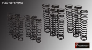 Various black metal springs arranged on a gray surface.