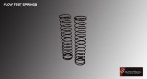 Two black metal coil springs standing upright on a gray surface.