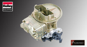 A metallic carburetor for an engine on a gray background.