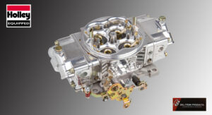 Shiny chrome carburetor with brass components on a gray background.