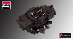 Close-up of a dark-colored carburetor on a gray background.