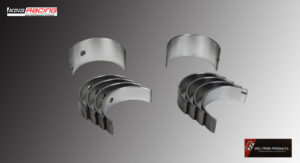 Set of shiny metal engine bearings arranged on a gray surface.