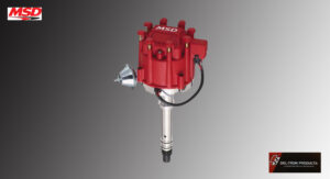 Red automotive ignition distributor with metal components and wiring.