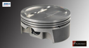 Close-up of a shiny metallic engine piston against a dark background.