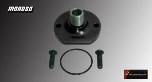 Black plastic mechanical part with two screws and a green O-ring on a gray background.