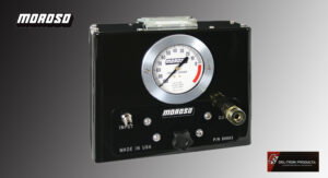 A black industrial control panel with a pressure gauge and switches.