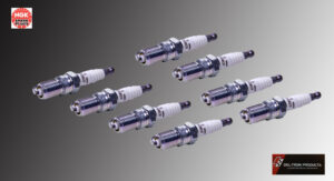 Multiple spark plugs arranged against a gradient background.