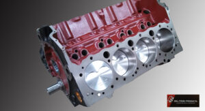 Close-up of a red engine block with polished cylinder heads.