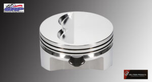 A shiny metallic piston with grooves and cutouts, used in engines.