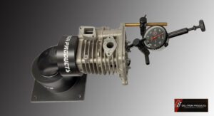 Close-up of a mechanical device with pressure gauge and black tubing.