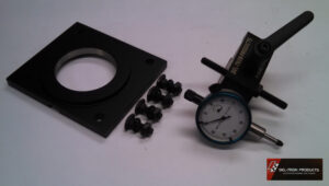 Dial indicator with mounting accessories on a table.