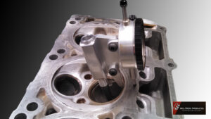 Precision measuring tool inspecting an engine cylinder head.